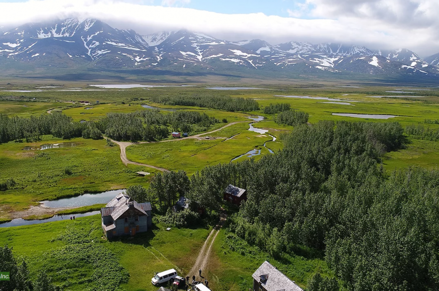 Landscape picture of Pilgrim Hot Springs showing road and building network with mountains in the background